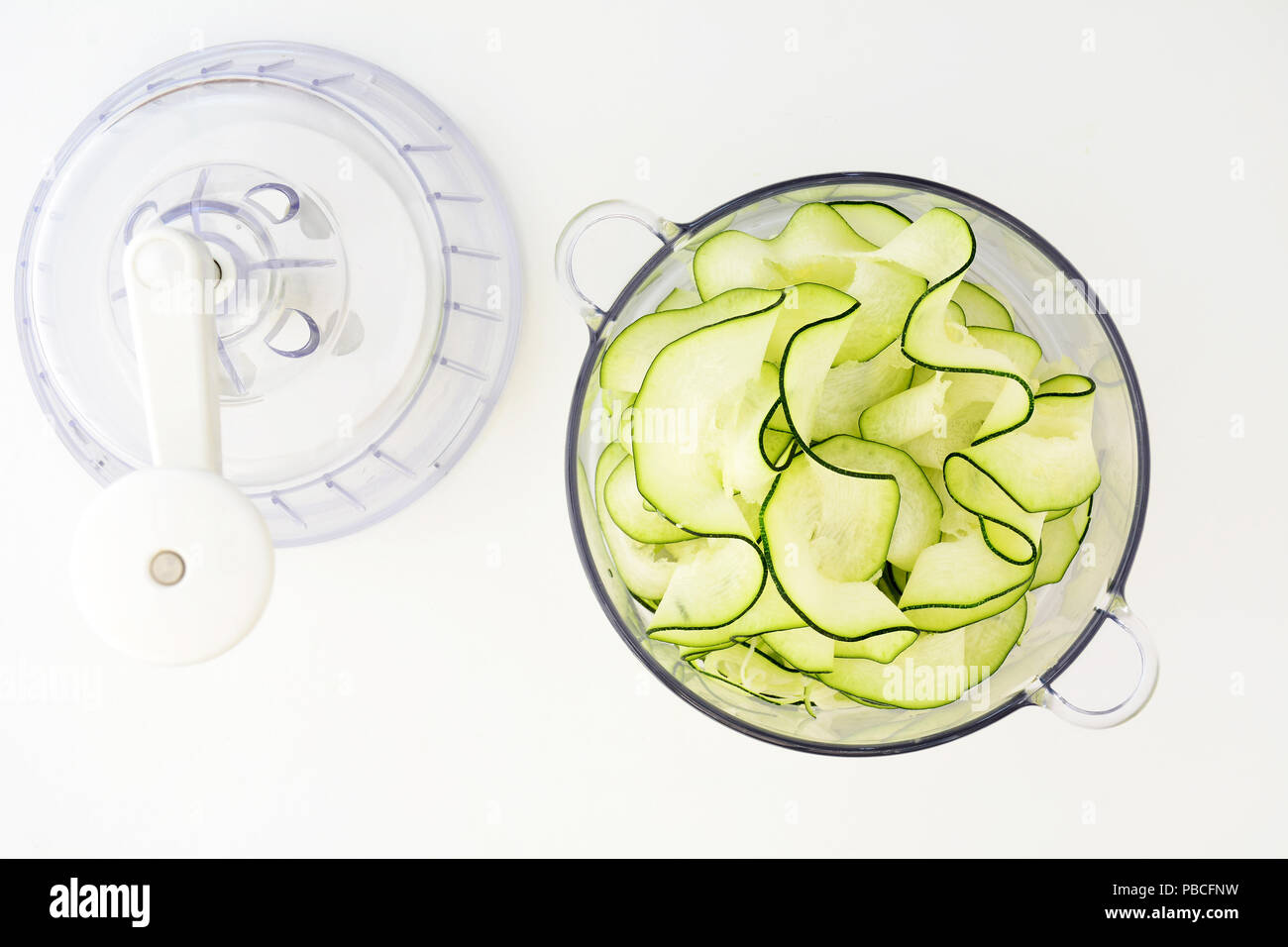 Zucchini Bänder mit spiralizer auf weißem Hintergrund in Flach Zusammensetzung Stockfoto