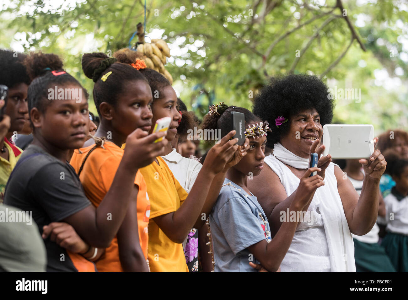 Die lokale Bevölkerung auf Mobiltelefone und Tabletten in Papua Neuguinea Stockfoto