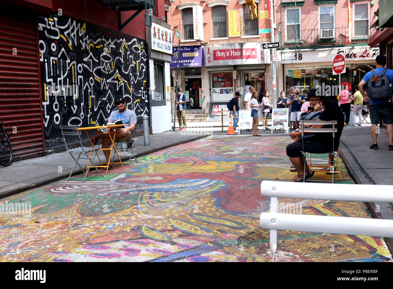 New York City, New York, USA. 28. Juli 2018. Eine 200-Fuß-Strecke von eine Straße in New Yorks Chinatown einmal als "die blutigen Winkel'' bekannt, aufgrund der Menge der Bandenkriminalität gibt, abgedeckt mit einer Technicolor Wandmalerei von Künstler Chen Dongfan und mit dem Titel "Das Lied der Drachen und Blumen." Die 4,851 Quadratfuß-Stück soll ein Flying Dragon Wicklung bis zur Doyers Street und ruhen auf dem Schnittpunkt zweier Straßen zu zeigen. Credit: G. Ronald Lopez/ZUMA Draht/Alamy leben Nachrichten Stockfoto