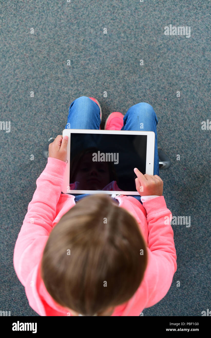 Mädchen 9 10 11 auf dem Ipad mit einem leeren Bildschirm kopieren Raum Grundschulalter Stockfoto