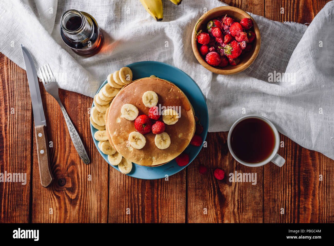 Frühstück mit hausgemachten Pfannkuchen, Obst und Tee. Blick von oben. Stockfoto