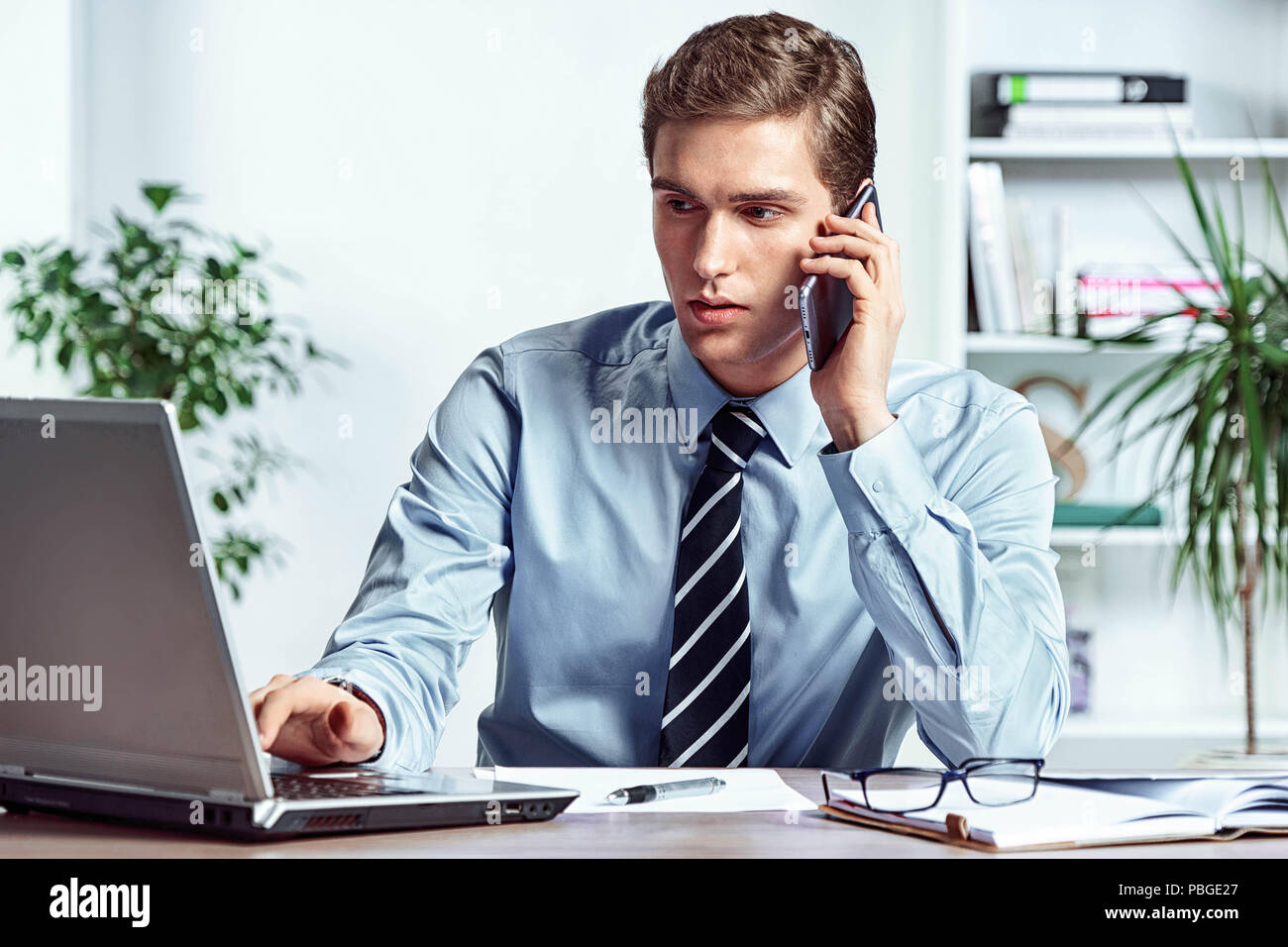 Arbeitnehmer, am Telefon zu sprechen und sich mit dem Laptop. Foto von erfolgreicher Manager arbeiten mit Finanzdaten im Büro. Business Konzept Stockfoto