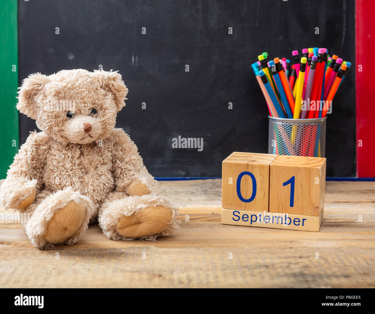 Zurück zu Schule. 1. September Datum, Teddybären und Bunte Bleistifte auf blackboard Hintergrund Stockfoto