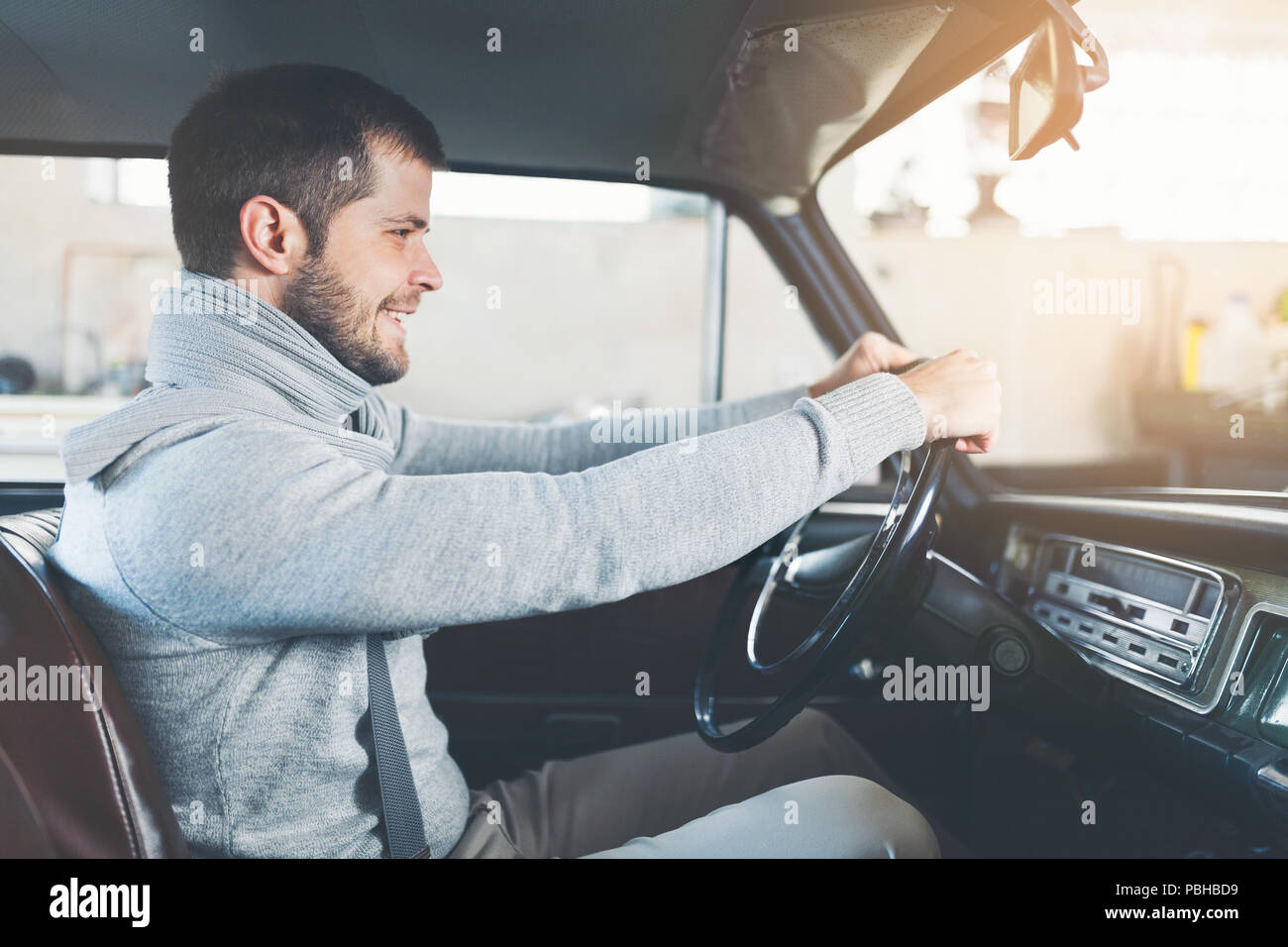 Schöner Mann in seinem alten Oldtimer sitzen Stockfoto