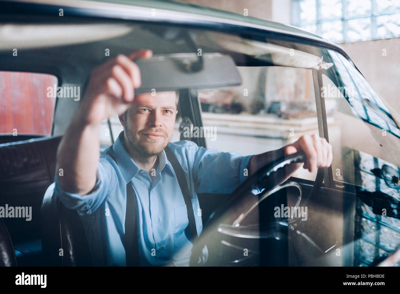 Schöner Mann in seinem alten Oldtimer sitzen Stockfoto