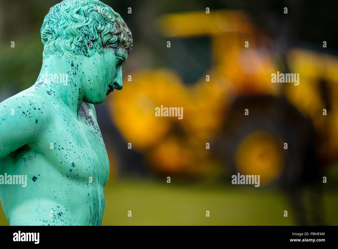 Statue des Narziss, römische Kopie eines griechischen Originals unbekannter Künstler aus dem 5. Jahrhundert v. Chr., gelben Bagger im Hintergrund Stockfoto