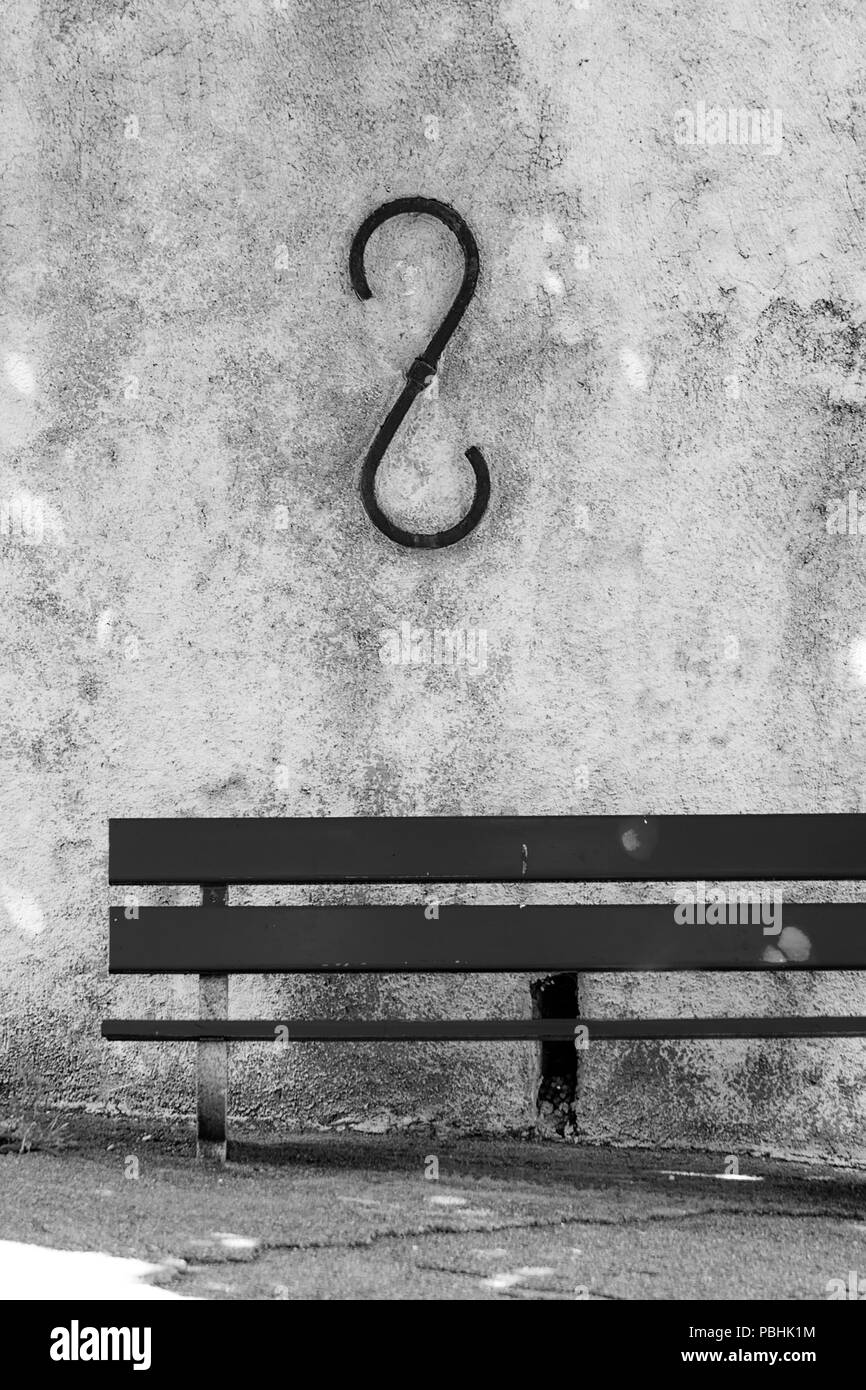 Holzbank allein in einer Nebenstraße mit einem grungy Wand auf dem Rücken. Stockfoto