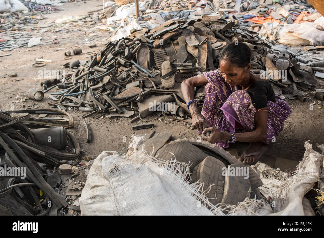 Frau recyceln Schuh Gummi in den Kolkata Deponie als Abfall Berg, Kolkata, West Bengal, Indien Stockfoto