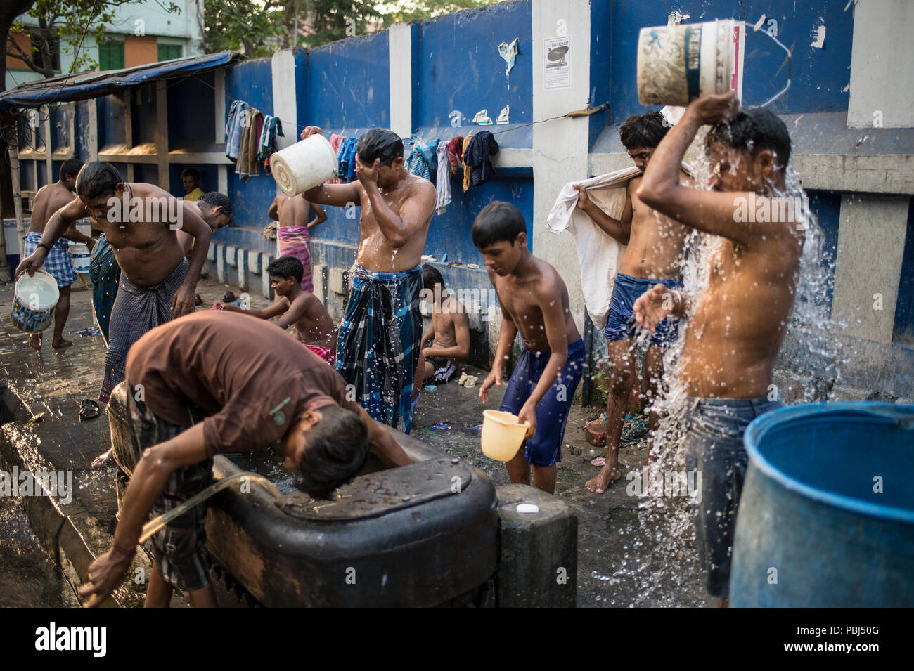 Die Menschen am frühen Morgen reinigen sich selbst in den Straßen von Kolkata (Kalkutta), West Bengal, Indien, Asien Stockfoto
