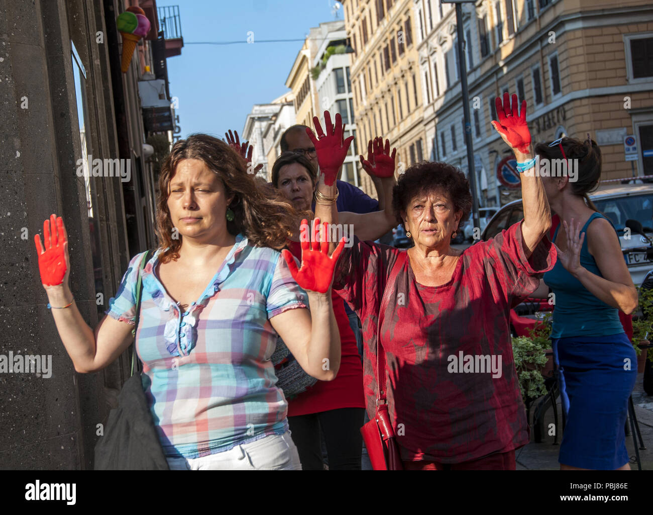 Rom, Italien. 27. Juli, 2018. Demonstration vor dem Ministerium des Innern genug, um die Toten zu sagen. Die Demonstranten, die in der Stille mit ihren Händen rot lackiert - rot, wie das Blut von Tausenden von Migranten im mediterranen Verschlucken oder in libyschen Gefängnissen gefoltert - gegen die Politik der Regierung auf Migranten und gegen die Italienische Entscheidungen im Hinblick auf die Steuerung der Migrationsströme protestiert marschierten. Credit: Patrizia Cortellessa/Pacific Press/Alamy leben Nachrichten Stockfoto