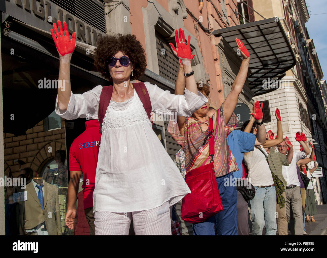 Rom, Italien. 27. Juli, 2018. Demonstration vor dem Ministerium des Innern genug, um die Toten zu sagen. Die Demonstranten, die in der Stille mit ihren Händen rot lackiert - rot, wie das Blut von Tausenden von Migranten im mediterranen Verschlucken oder in libyschen Gefängnissen gefoltert - gegen die Politik der Regierung auf Migranten und gegen die Italienische Entscheidungen im Hinblick auf die Steuerung der Migrationsströme protestiert marschierten. Credit: Patrizia Cortellessa/Pacific Press/Alamy leben Nachrichten Stockfoto