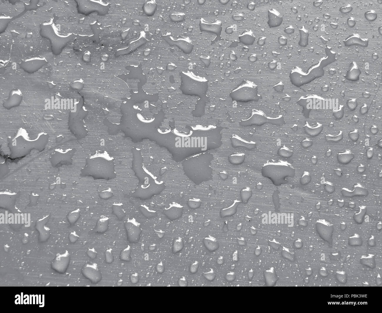 Wassertropfen auf ruhige graue metallische Oberfläche. Stockfoto