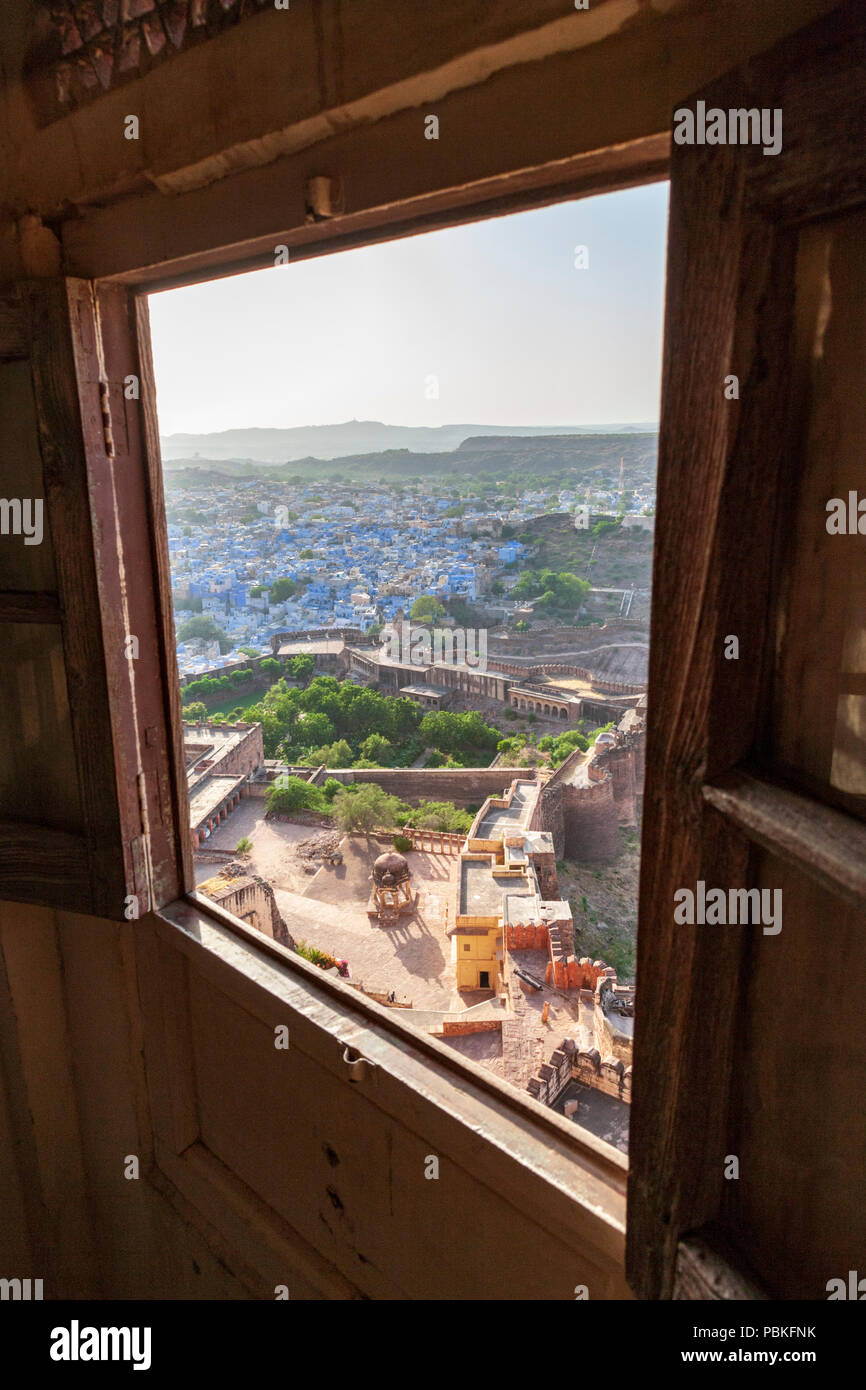 Blick auf die blauen Häuser von Jodhpur und Festung Verteidigung durch ein Fenster bei Mehrangarh Fort Fenster, Jodhpur, Indien Stockfoto