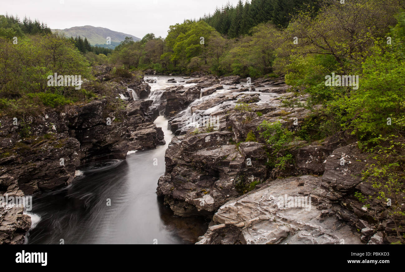 Der Fluß Orchy stolpert über kleinen felsigen Wasserfällen im Glen Orchy, inmitten der Bäume eines Kaledonischen Wald in den westlichen Highlands von Schottland. Stockfoto
