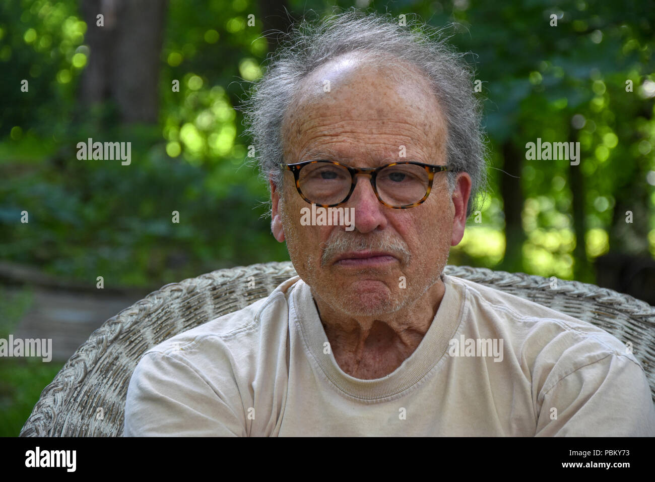 Ernster Mann draußen sitzen Stockfoto