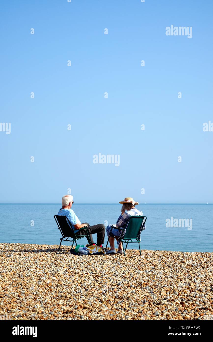 Ältere weiß Paar am Strand von Hastings an einem heissen Sommertag, East Sussex England Großbritannien Stockfoto