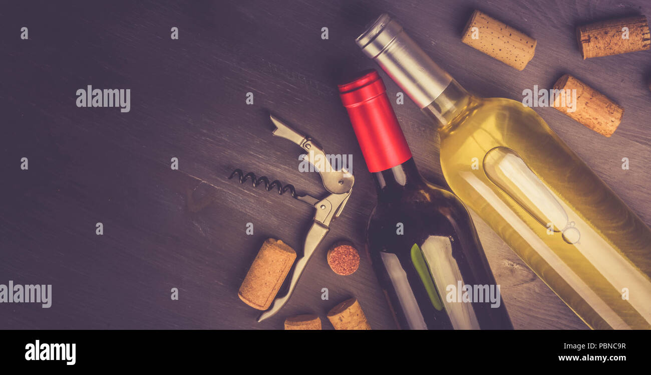 Flaschen Rot- und Weißwein mit Naturkorken auf hölzernen Tablet, getönten Bild, Banner Stockfoto