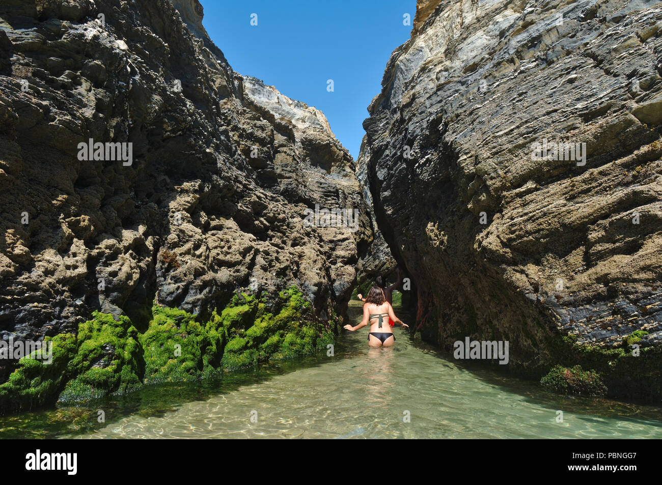 Touristen erkunden die versteckten Höhlen und Strände in der Südwestküste von Porto Covo. Alentejo, Portugal Stockfoto