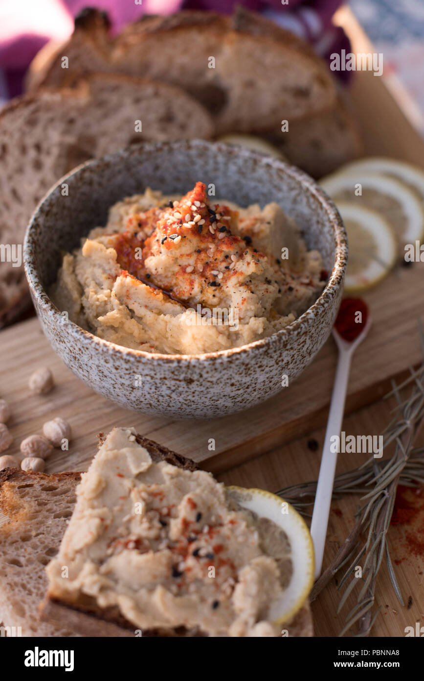 Hummus mit Vollkorn Sauerteigbrot, Paprika und Zitrone Stockfoto