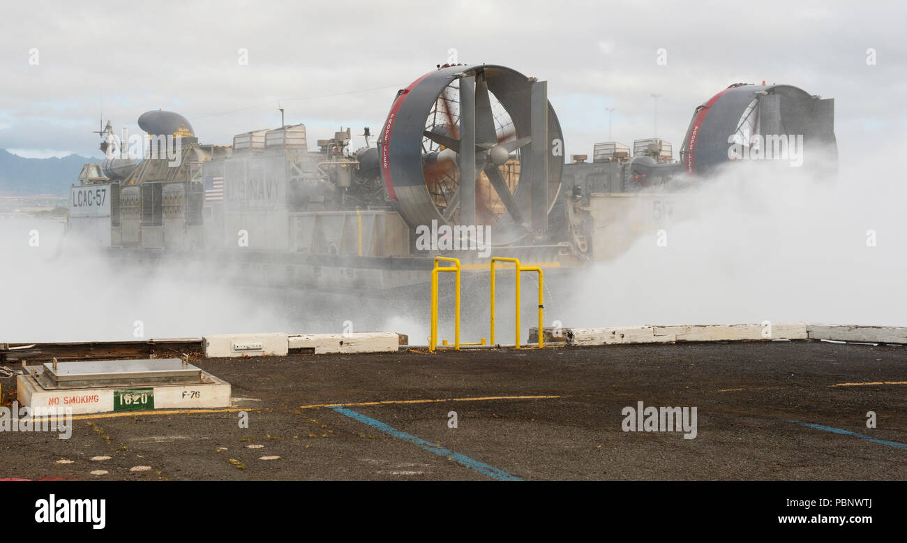 180726-N-SB 520-4015 Pearl Harbor (Juli 26, 2018) eine Landing Craft Air Cushion (LCAC) in Angriff Craft Unit (ACU) 5 Starts aus dem Deck des Amphibious Assault ship USS BONHOMME RICHARD (LHD6), während der Übertragung an den amphibious Transport dock USS John Murtha (LPD S. 26) am Joint Base Pearl Harbor-Hickam als Teil der Felge des Pazifiks (Rimpac) Übung, Juli 26 befestigt. Das lcac ist ein high-speed, über - Strand, voll amphibische Landung Handwerk in der Lage, die eine 60-75 Tonne payloadTwenty - fünf Nationen, 46 Schiffe, 5 U-Boote, über 200 Flugzeuge und 25.000 Mitarbeiter in RIM teilnehmen. Stockfoto