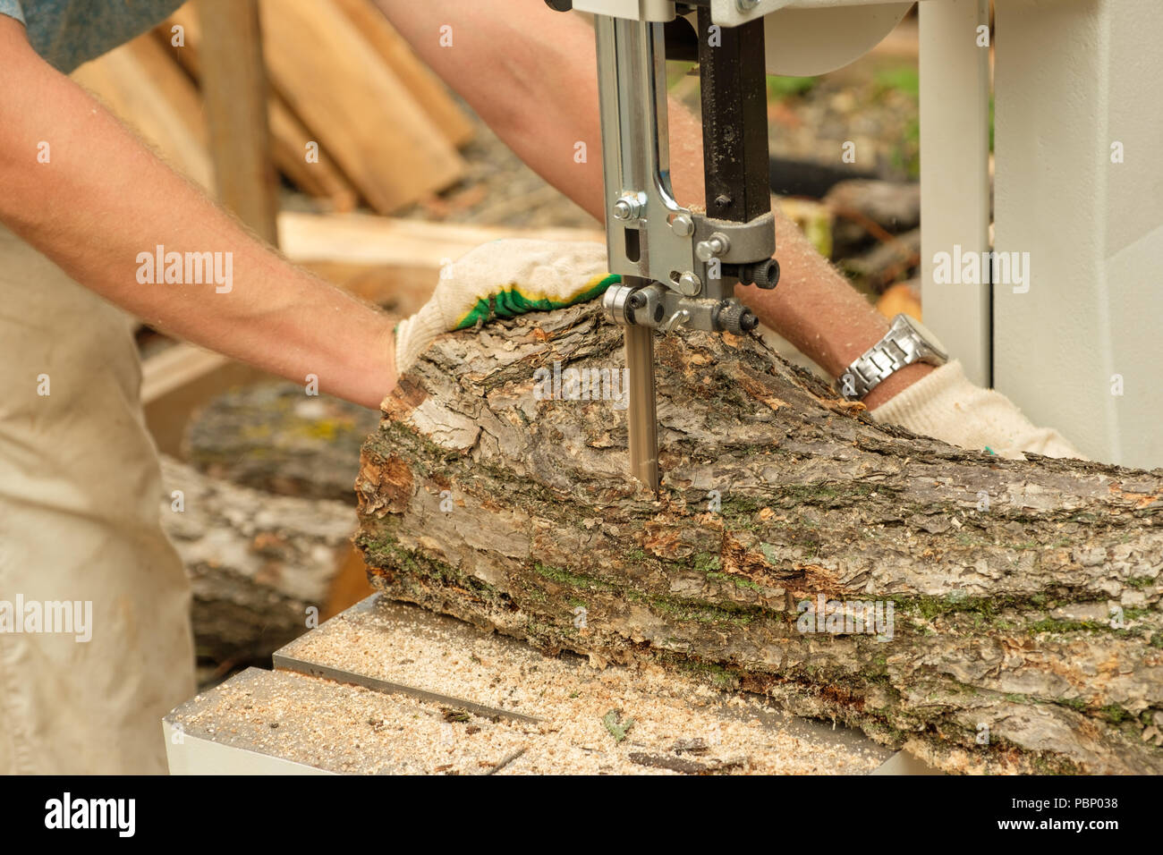 Auf einem Foto Arbeiten des Zimmermanns Schneiden von einem Baum auf der Holzbearbeitungsmaschine. Stockfoto