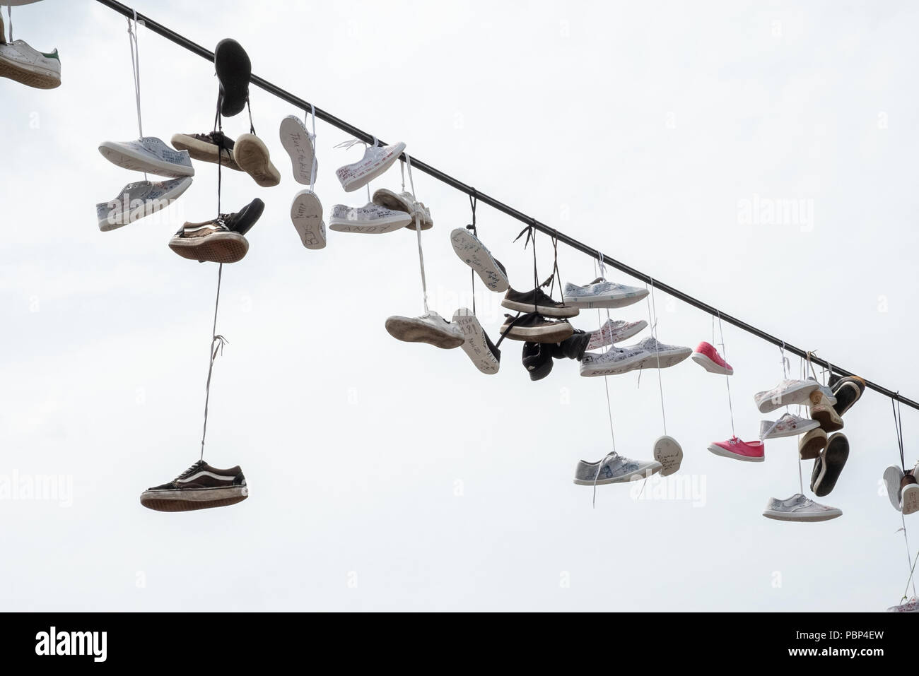 Linie der Paare Schuhe hängen an einer Leitung neben dem Metronom in Prag  Stockfotografie - Alamy