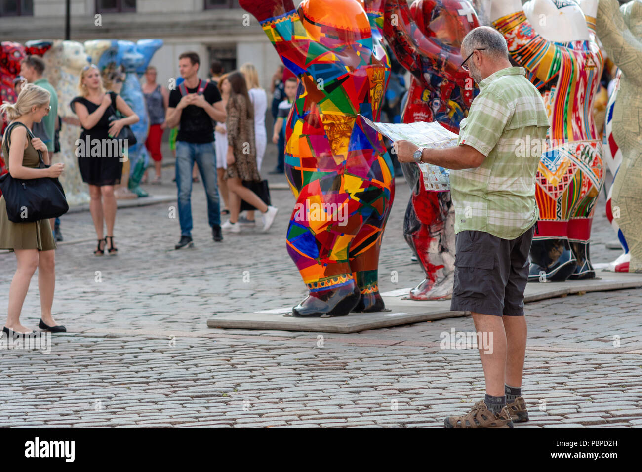 RIGA, Lettland - 26. JULI 2018: United Buddy Bears Ausstellung. Stadtbewohner und Touristen betrachten und fotografieren die Ausstellung in der Alten zu Stockfoto