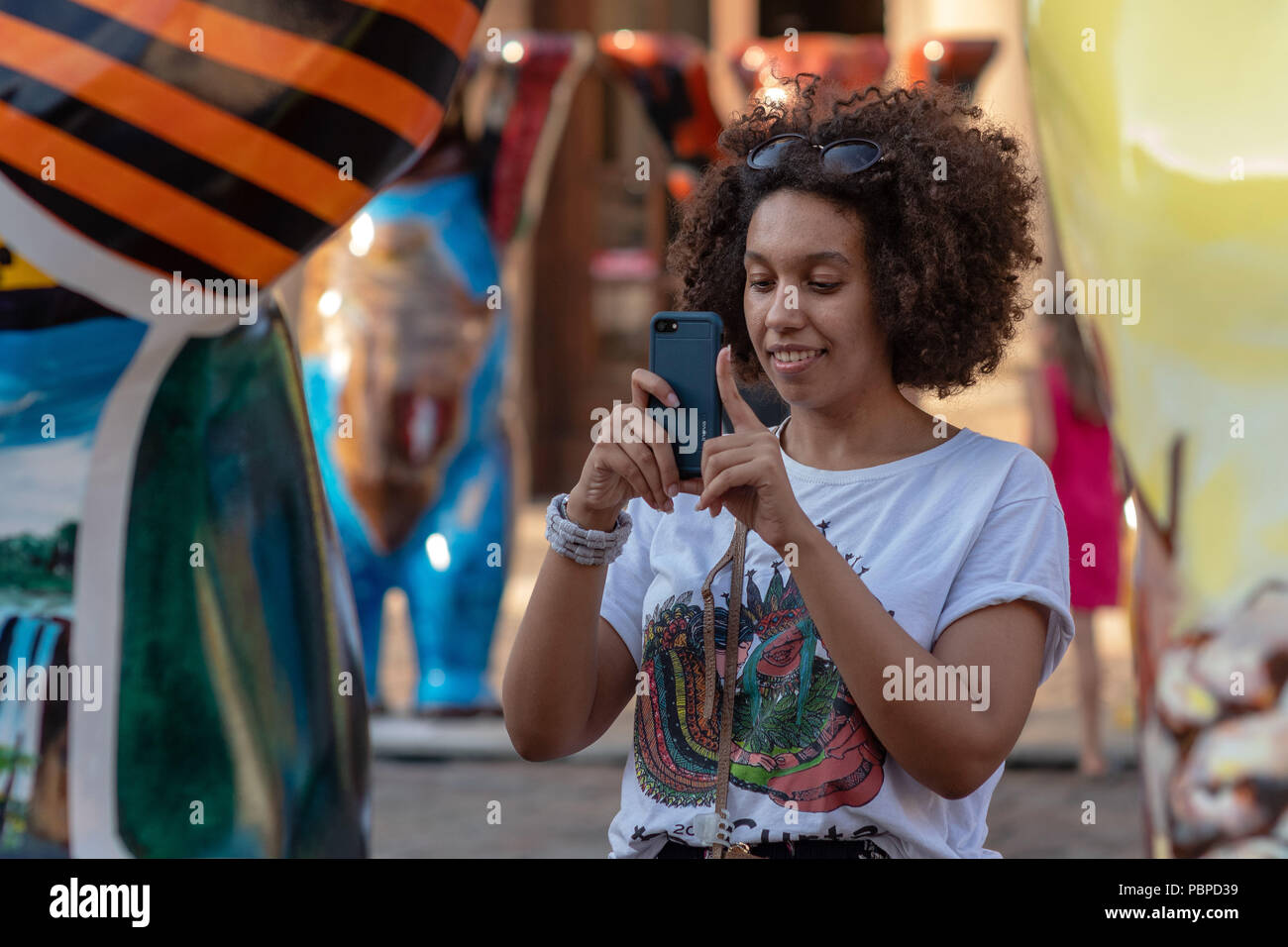 RIGA, Lettland - 26. JULI 2018: United Buddy Bears Ausstellung. Eine Frau mit einem Telefon nimmt Bilder von Bär Skulpturen. Stockfoto