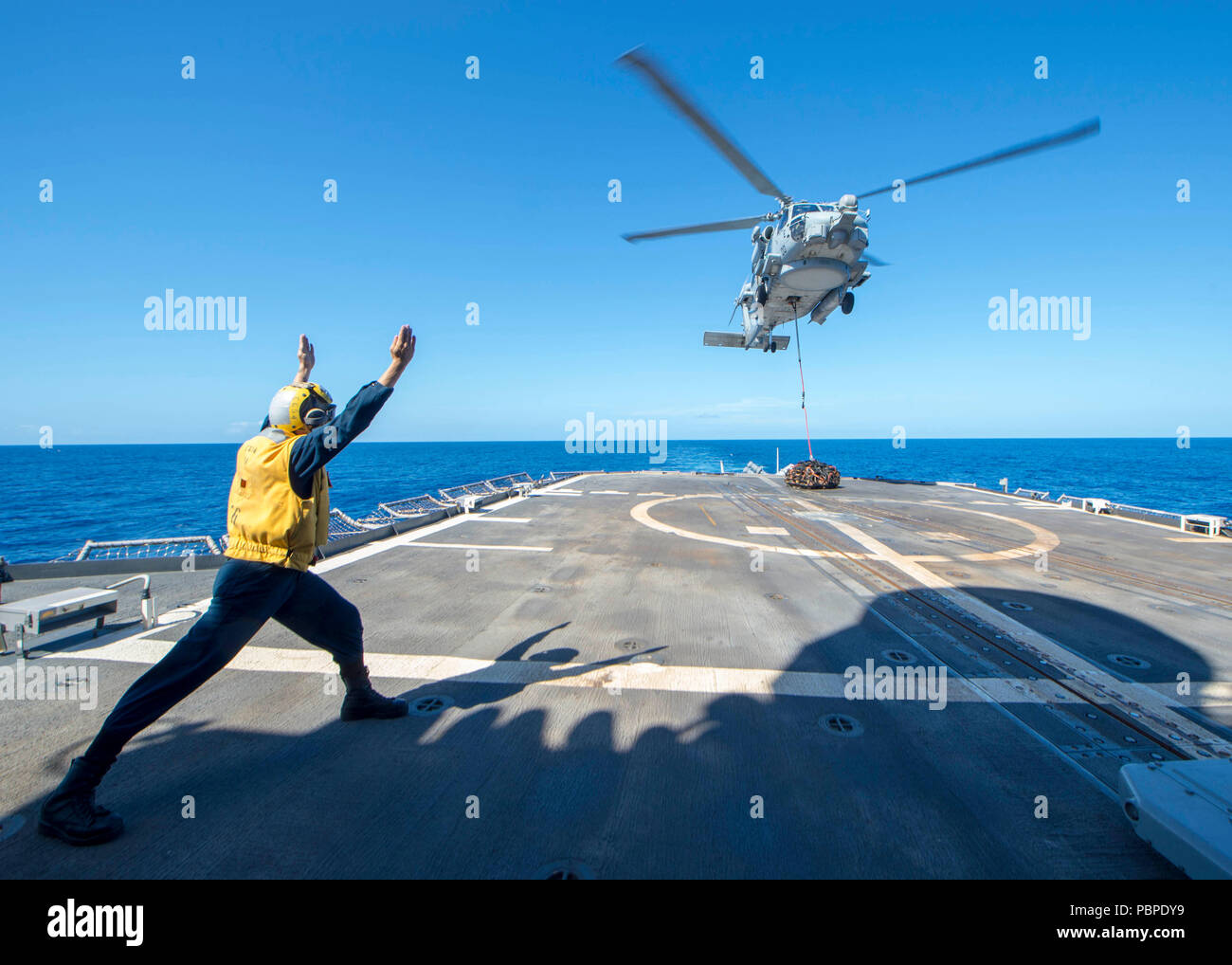 180720-N-ER 318-1159 philippinischen Meer (20. Juli 2018) Der Bootsmann Mate 3. Klasse Aaron Mason, von Lafayette, Indiana, Signale zu einem MH-60R Sea Hawk Hubschrauber, der "Warlords" von Hubschrauber Maritime Strike Squadron (HSM) 51 zugeordnet, da sie schwebt über dem Flight Deck der Ticonderoga-Klasse geführte-missile Cruiser USS Antietam (CG54). Antietam freut - in den USA 7 Flotte Bereich für Maßnahmen zur Erhöhung der Sicherheit und Stabilität in der indopazifischen Region bereitgestellt. (U.S. Marine Foto von Mass Communication Specialist 2. Klasse William McCann/Freigegeben) Stockfoto