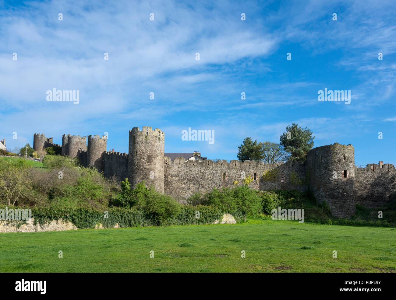 Die mittelalterliche Stadtmauer in Conwy in Nord Wales, Großbritannien. Ein sonniger Frühlingstag auf der ausserhalb der Stadt. Stockfoto
