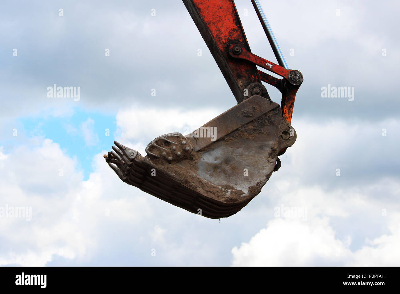 Die Schaufel des Baggers wird angehoben, nach oben, in die die Schaufeln der Arbeiter versteckt sind. Schutz vor Diebstahl auf der Baustelle. der Instandsetzung Stockfoto