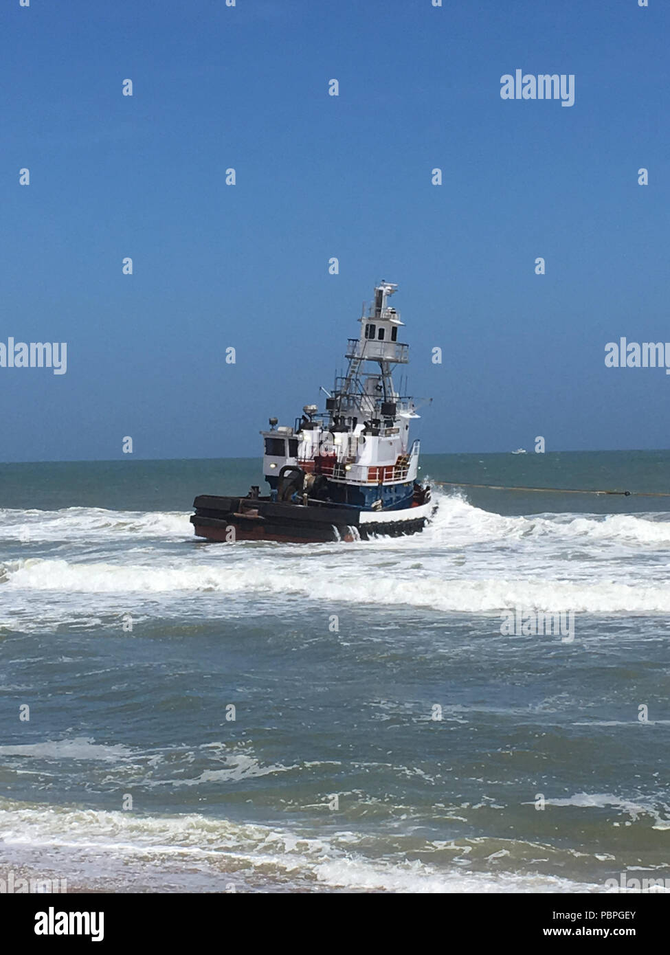 Der Tug Boat Sea Cypress beruht auf dem Strand in Lavallette, New Jersey, 24. Juli 2018. Coast Guard Personal, die zusammen mit lokalen Partnerorganisationen, Arbeiten, um das Schiff vom Strand zu entfernen. (Küstenwache Foto von Chief Warrant Officer Todd M. Wardwell) Stockfoto