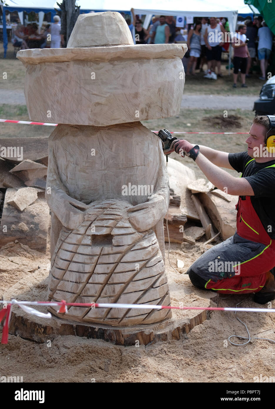 Tornau, Deutschland. 29. Juli, 2018. Holz Bildhauer Christian Seidel aus Sachsen-anhalt mit der Arbeit an seinem Werk "Bienenwaechter' ('Imker"). Im 19 Holz Skulptur Wettbewerb in Duebener Heide Naturpark 40 Kreativen aus fast 10 Nationen gegeneinander an. Die Künstler erhalten jeweils einen hölzernen Stamm etwa zwei bis drei Meter hoch, die Sie in eine Skulptur verwandeln. Das Motto der diesjährigen Holz Skulptur Wettbewerb war', wenn die Bienen sterben, stirbt". Credit: Sebastian Willnow/dpa-Zentralbild/ZB/dpa/Alamy leben Nachrichten Stockfoto