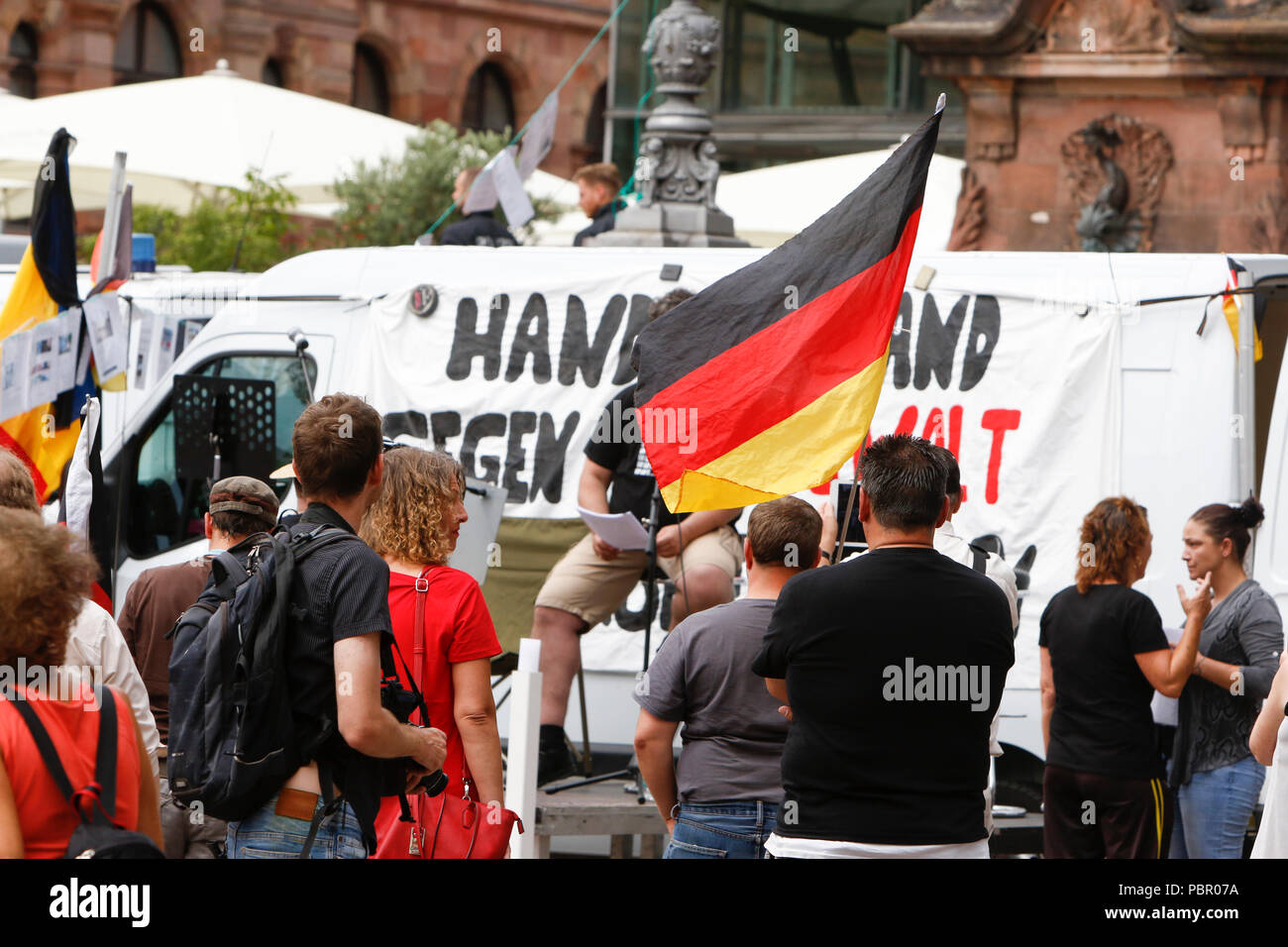 Wiesbaden, Deutschland. 29. Juli 2018. Rechtsradikale Demonstranten hören den Reden. Rechtsextreme Demonstranten der Hand in Hand-Gegen die Gewalt in unseren Strasen (Hand in Hand - gegen Gewalt auf unseren Straßen) Bewegung statt einer regierungsfeindlichen Kundgebung in Wiesbaden. Dieser Protest war unter dem Vorwand, eine Mahnwache für den Jugendlichen Susanna F, der angeblich von einem Flüchtling in Wiesbaden getötet wurde. Die Kundgebung wurde von mehreren Anti-government Referenten, die forderte, dass die Regierung zum Rücktritt gerichtet. Stockfoto