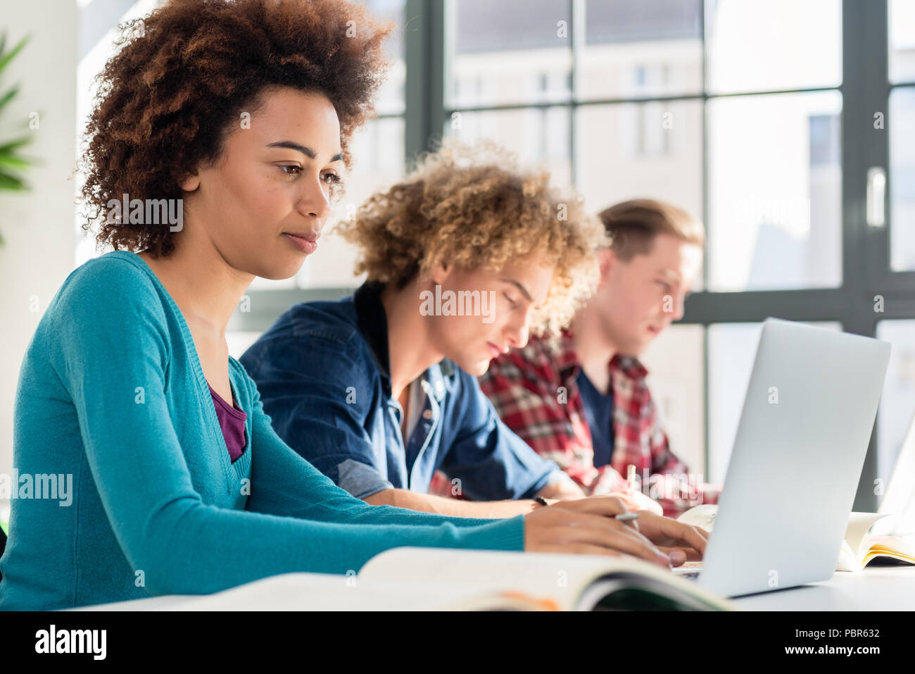 Student lächelnd, während Sie einen Laptop für On-line-Informationen Stockfoto