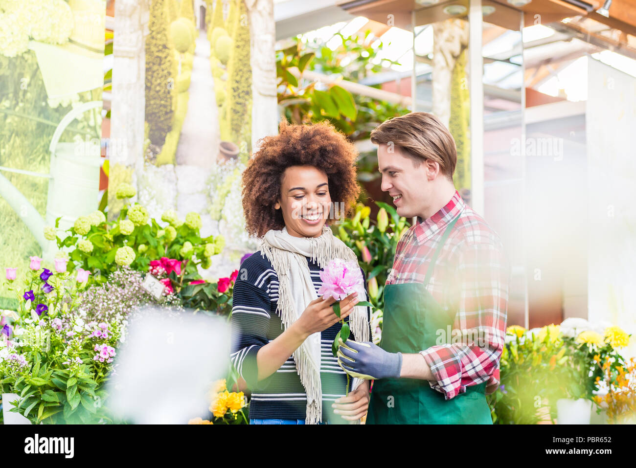 Freundliche weibliche Kunden kaufen Blumen an den Rat von einem hilfsbereiten Verkäufer Stockfoto
