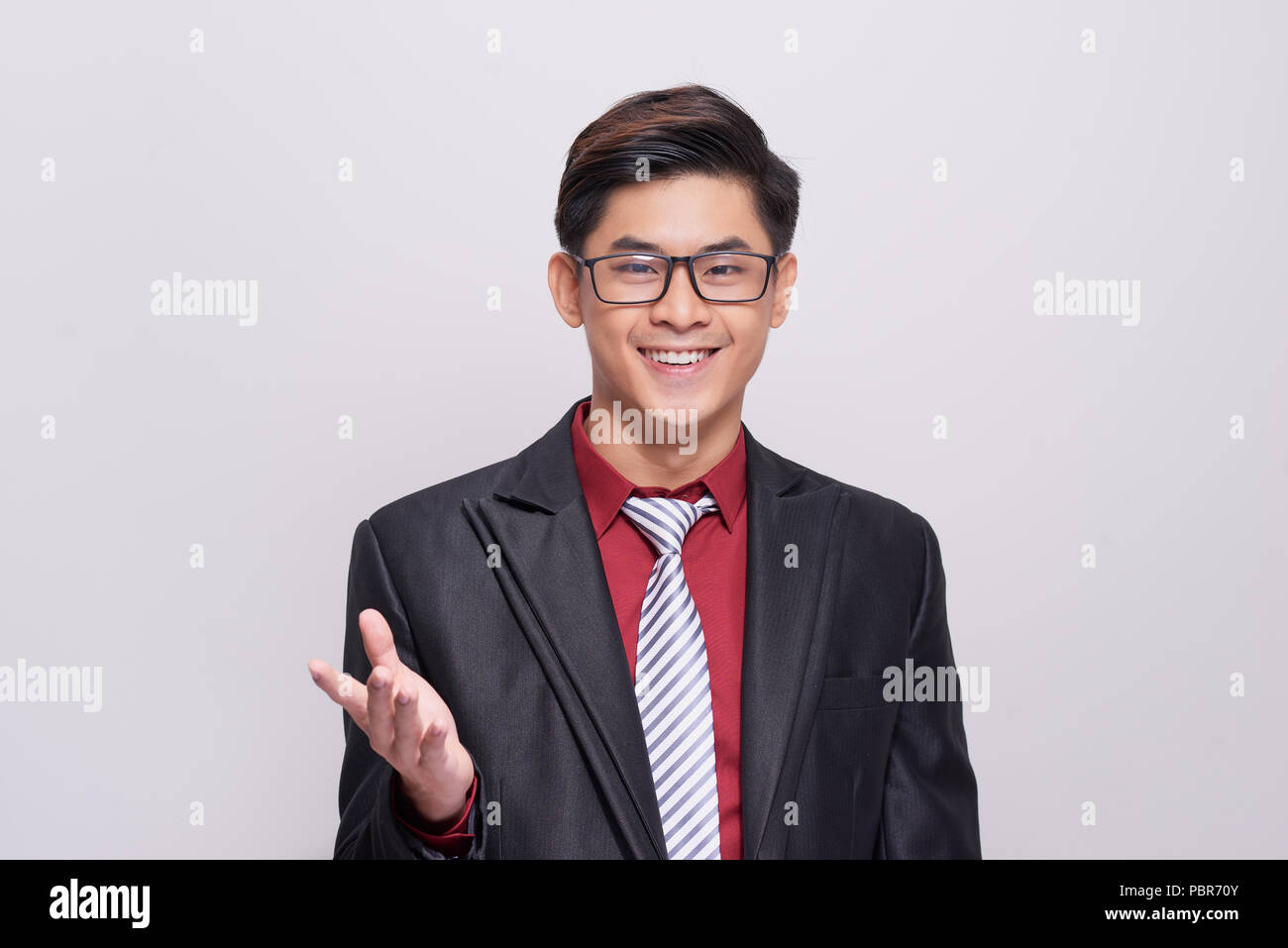 Schön und gut gekleidete Geschäftsmann im Anzug, Krawatte und Weste, vor einem weißen Hintergrund in Richtung Kamera lächelnd stehen. Stockfoto