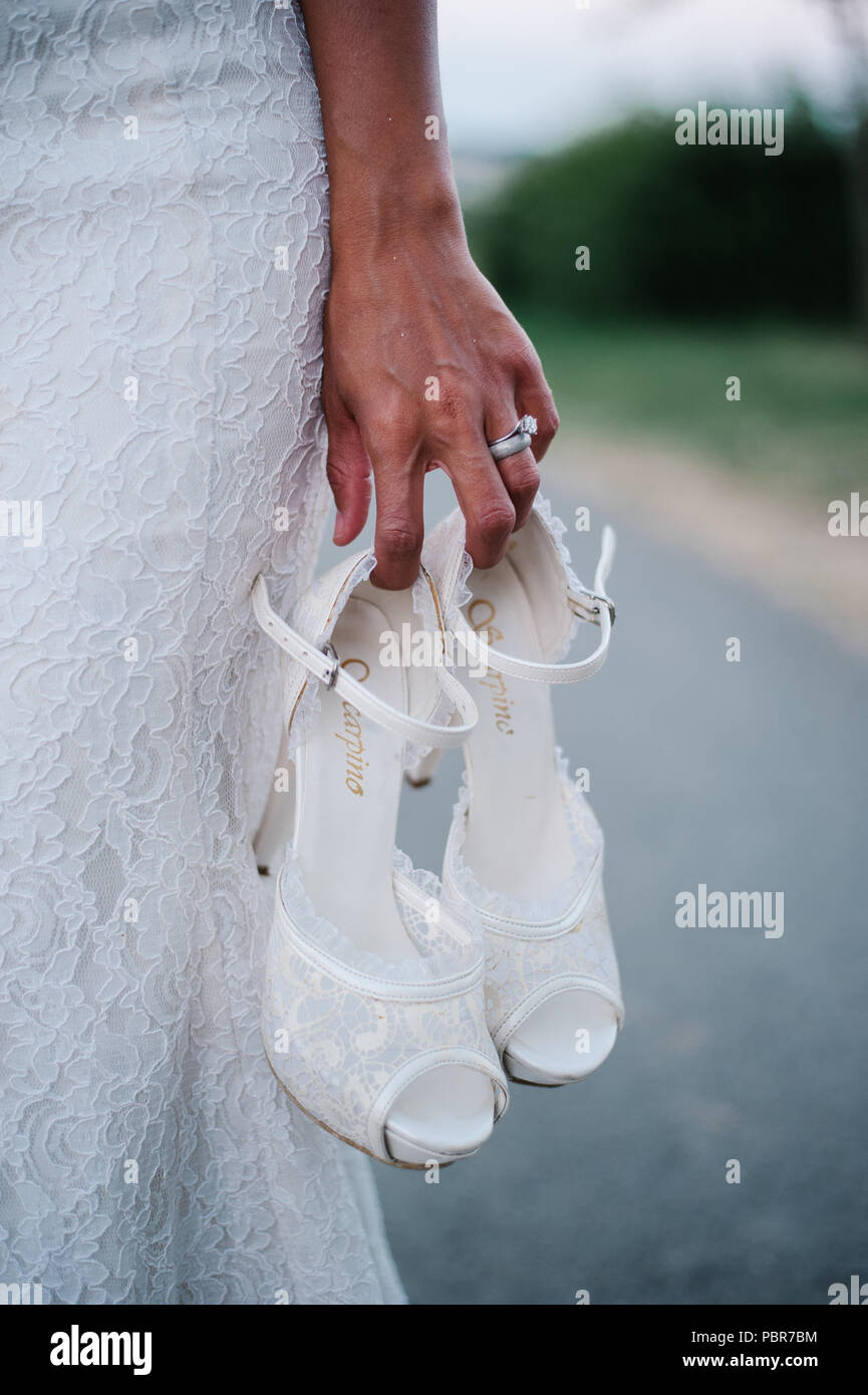 Braut ihre Schuhe in der Hand halten Stockfoto