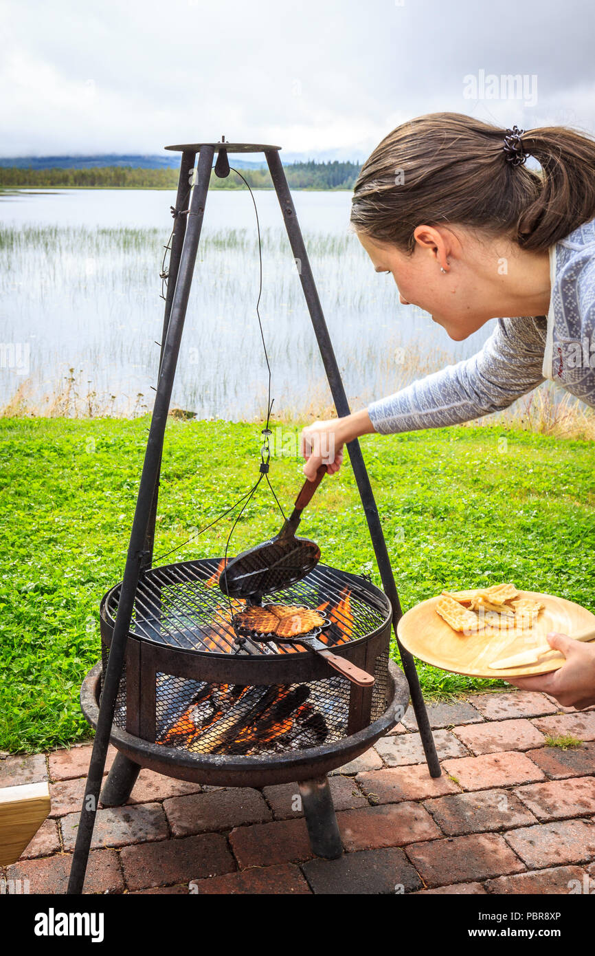 Vorbereitung Waffeln auf einem alten Gusseisen Waffeleisen, auf offenem  Feuer im freien Campingplatz. Bon Feuer auf Stativ Stockfotografie - Alamy