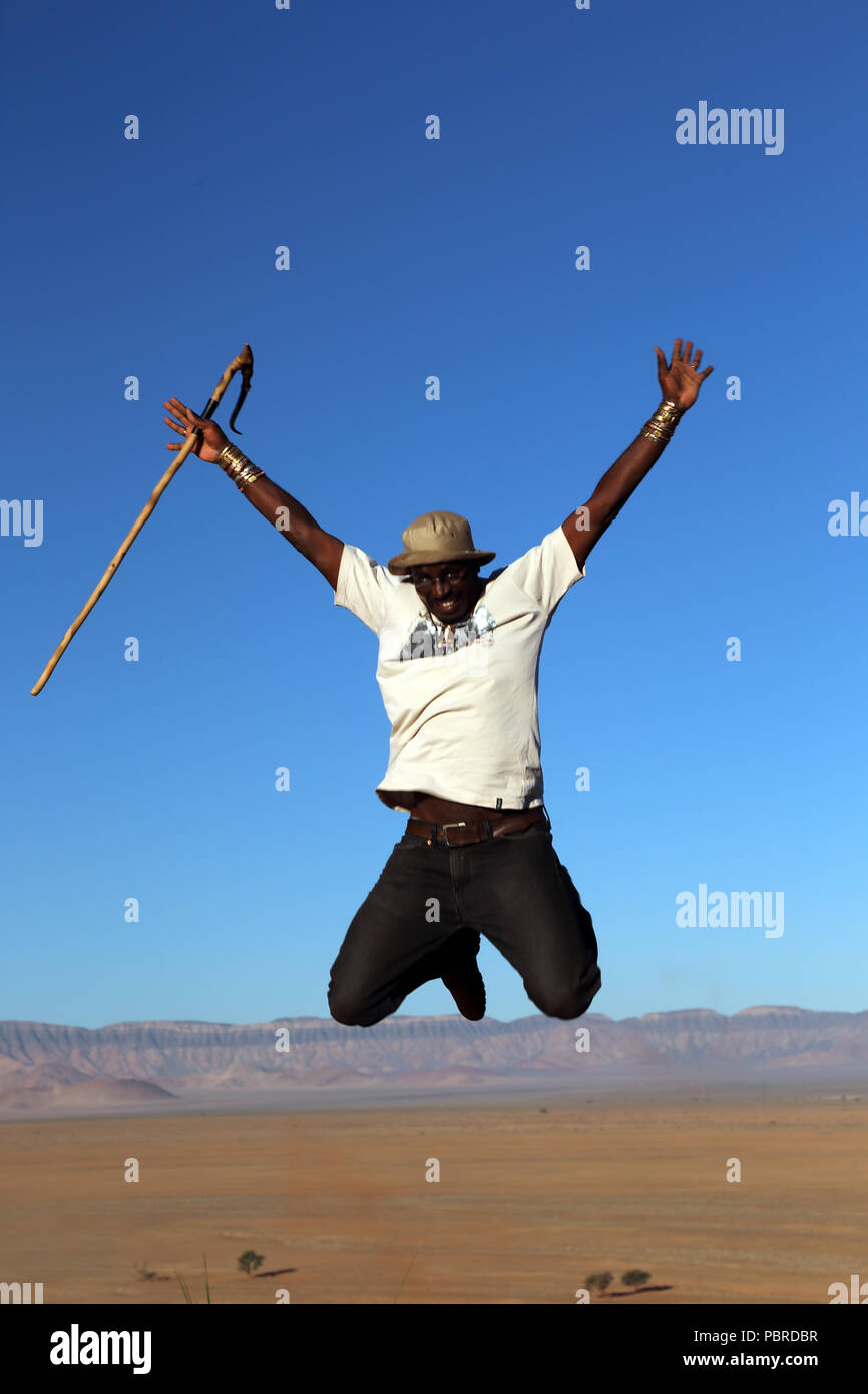 Ein Reiseleiter Sprünge für Freude an der Spitze der Elim Düne in den Namib-Naukluft-Nationalpark, Namibia. Stockfoto