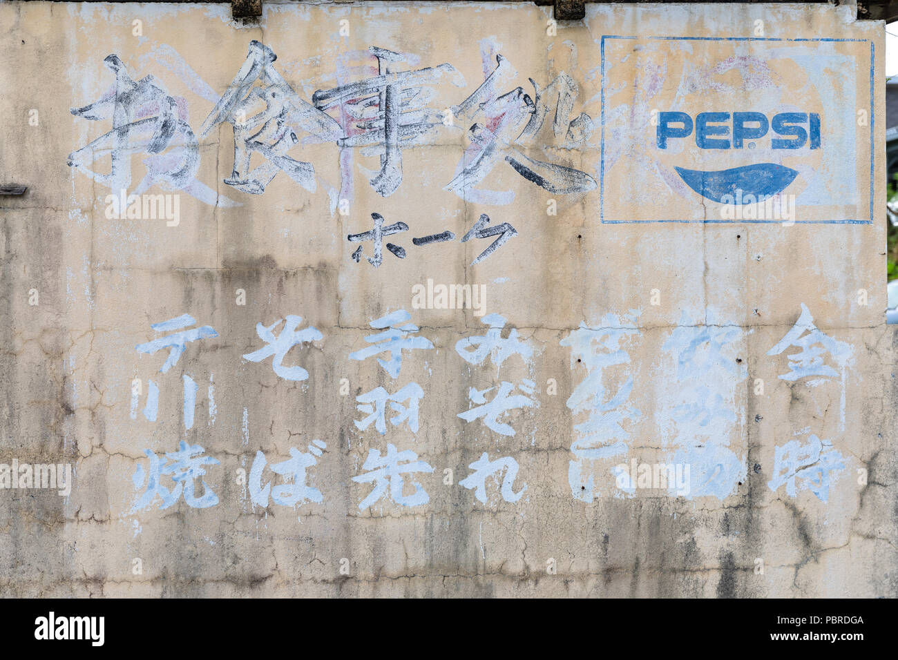 Verblasste Pepsi logo und japanischen Text auf Beton Wand; Joensuu, Präfektur Okinawa, Japan Stockfoto