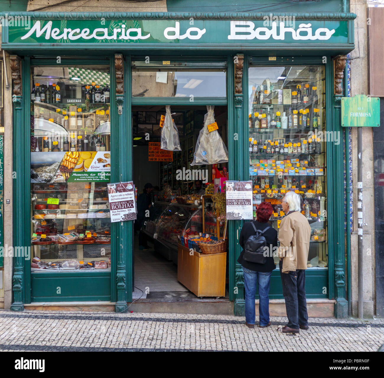 Eine ältere couiple Blick in die Schaufenster der Mercearia do Bolhão ein Essen und Wein Speicher zuerst im Jahre 1880 etablierten in der bolhão Viertel von Porto Stockfoto