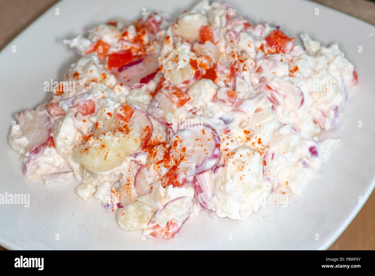 Blumenkohl Smash ein Kartoffelsalat Ersatz das ist low carb und gut für alle auf der Keto Diät. Von Blumenkohl, Radieschen, süßen Zwiebeln und Rot Stockfoto