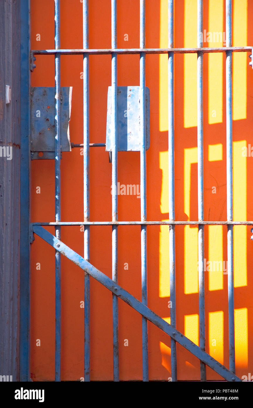 Blue Iron Gate über orange Tür Stockfoto