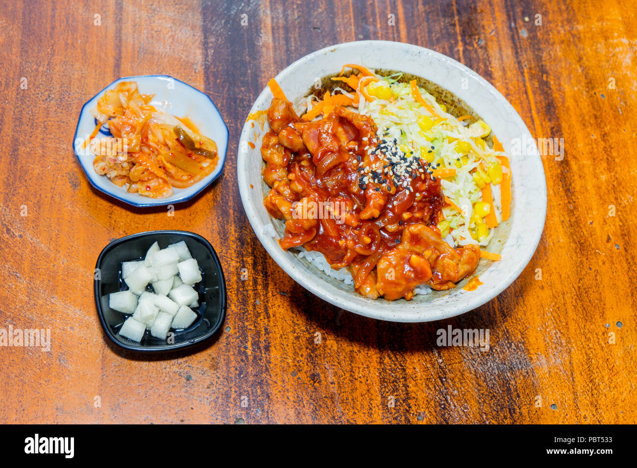 Koreanische rühren gebratene Hähnchen Reis mit köstlichen Honig Knoblauch Ingwer glasierte und Mais dienen in einer Schüssel auf hölzernen Tisch Stockfoto