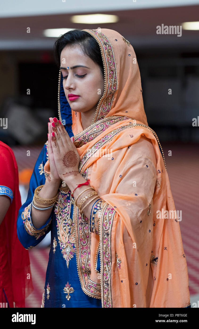 Eine wunderschöne Hochzeit Gast betet und meditiert, bevor die Zeremonie an einem Sikh Hochzeit in Richmond Hill, Queens, New York. Stockfoto