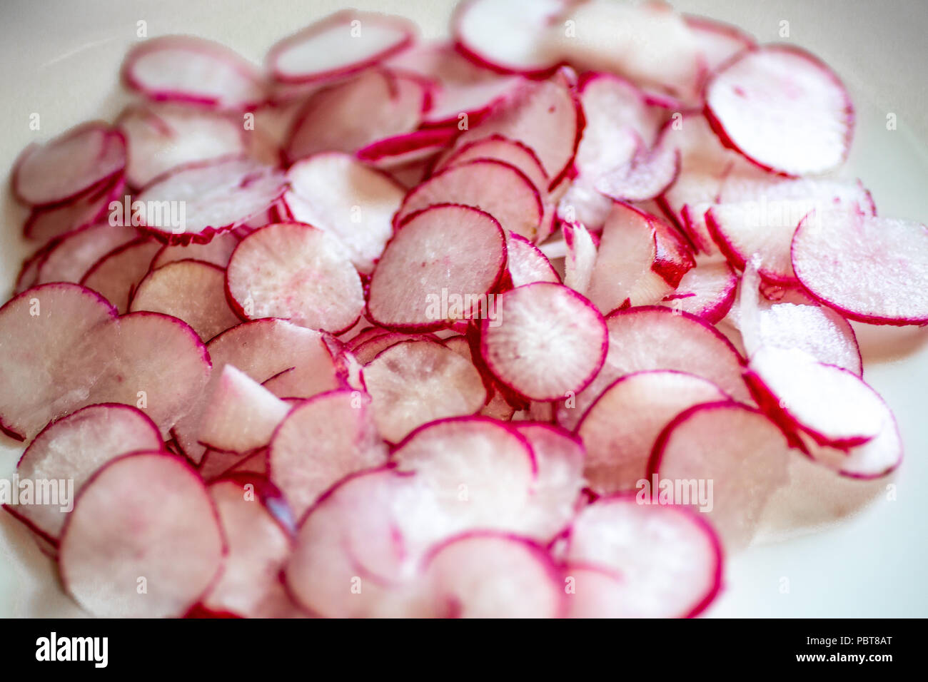 Platte voll von frisch geschnittenen Radieschen auf der Arbeitsplatte in der Küche warten auf den Küchenchef in einem Rezept zu verwenden. Stockfoto