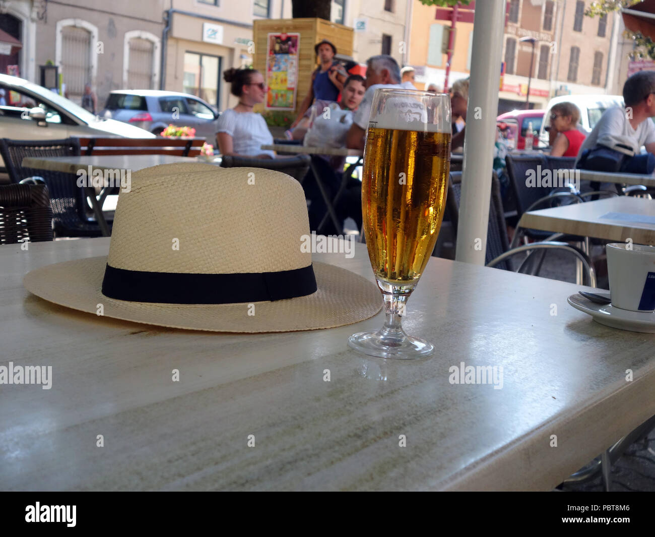 Entspannt , Hut ab jetzt eine willkommene Kühle Glas der Französischen Bier an einem Street Cafe in Saint-Chinian, Frankreich Stockfoto