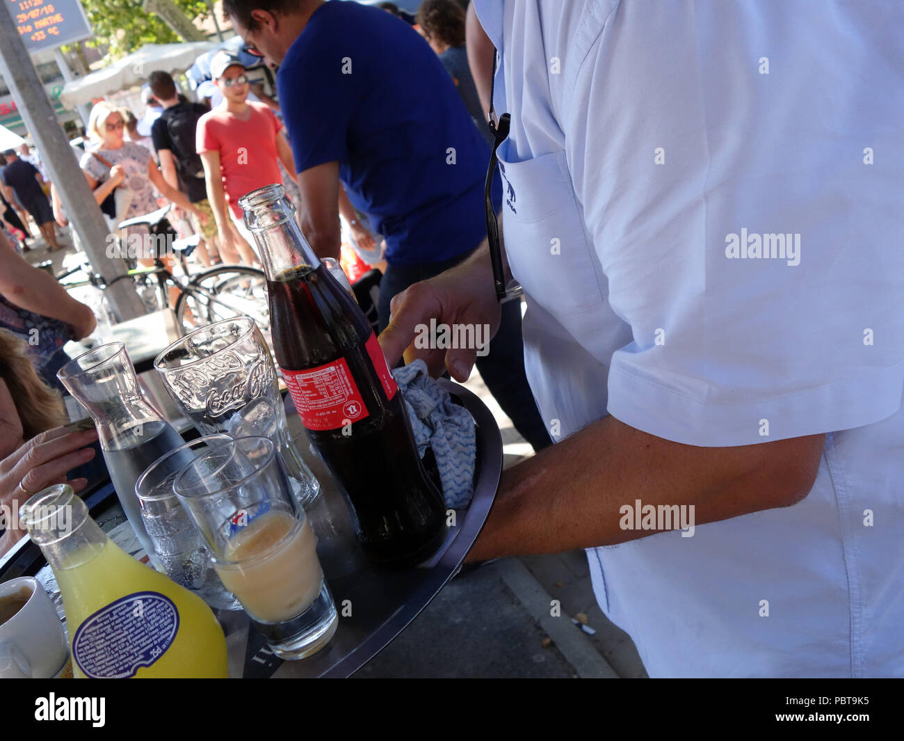 Kellner bringt Trinken um den Tisch im Cafe in Frankreich Stockfoto