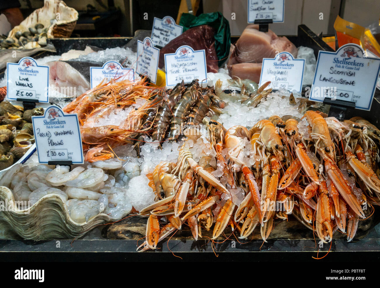 Auswahl an Meeresfrüchten: Lebende Wellhornschnecken, Vannamei Garnelen, madagassischen Tiger Garnelen, schottischen Langustinen, geschälte Garnelen, Thunfisch, Lende, im Verkauf bei Shellseekers Stockfoto